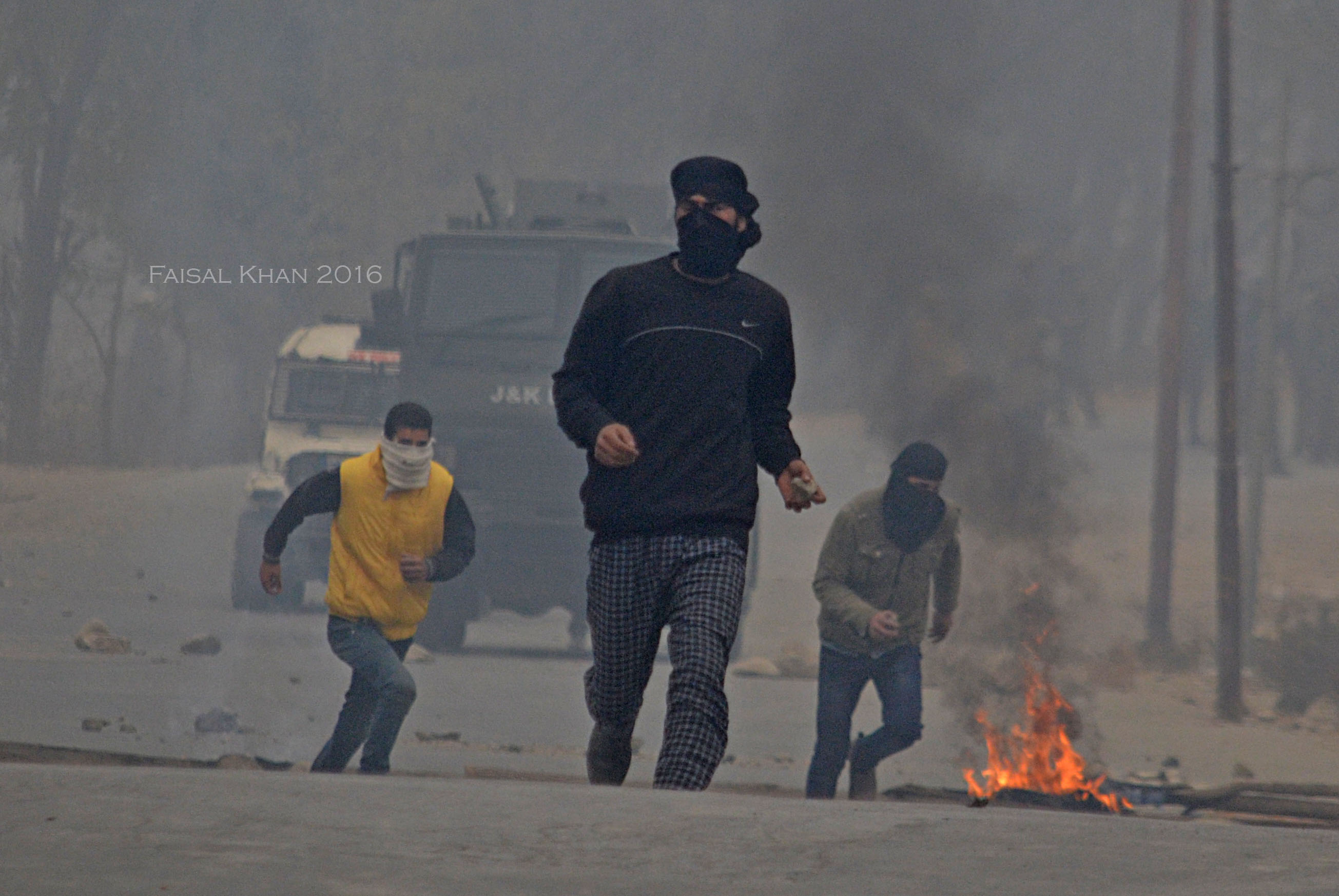 Youth run after being chased by the police at Kakapora Pulwama on Sunday. 