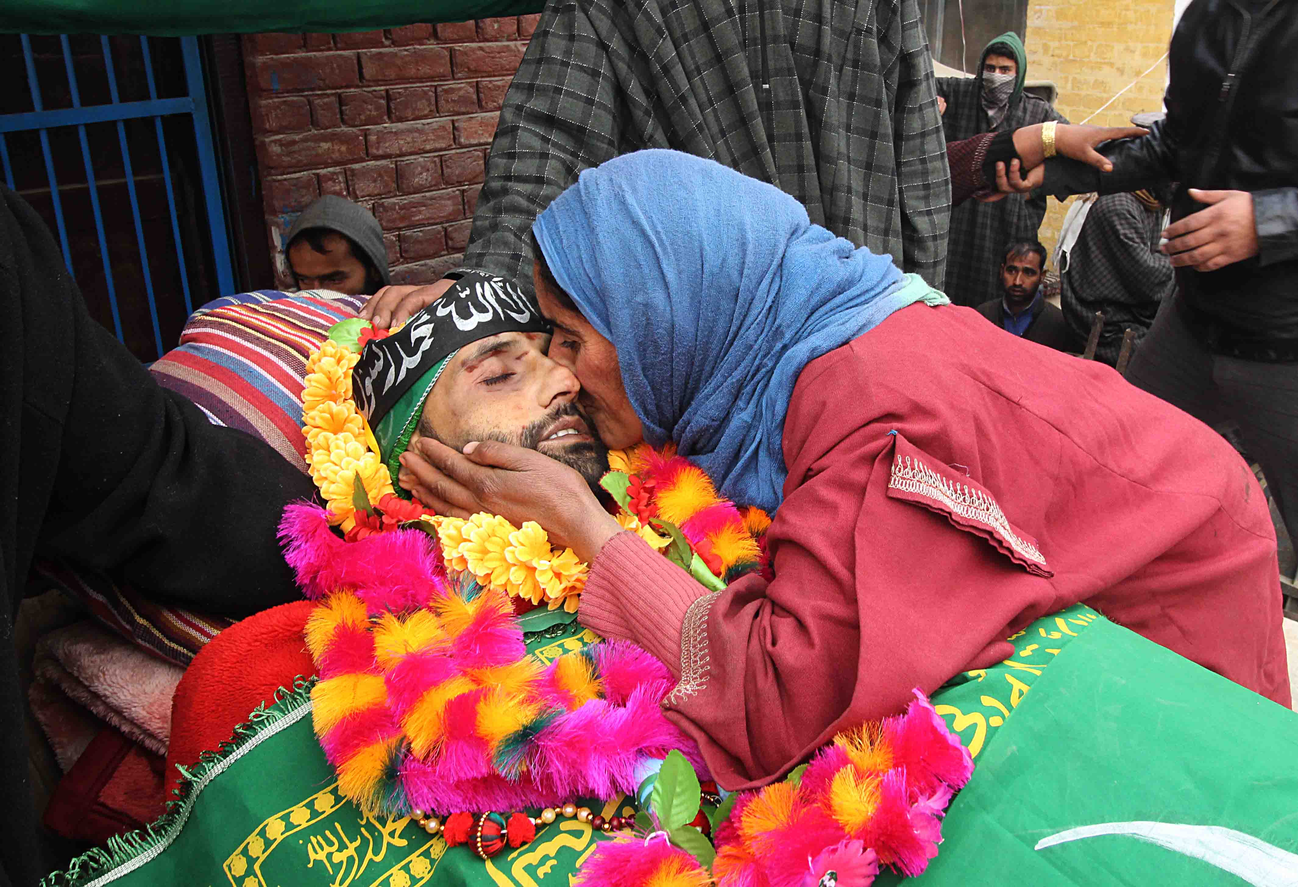 A woman kisses the face of the slain Lashkar-e-Toiba militant Rayees Ahmad Dar on Sunday in Kakapora, Pulwama. 