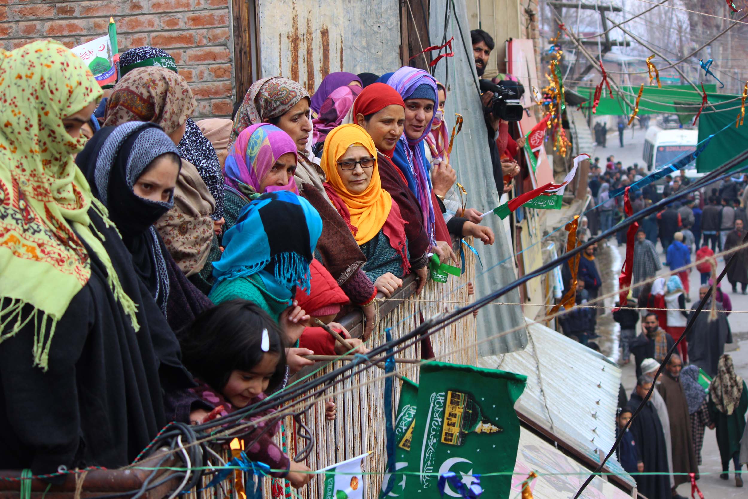 Women watch a milad procession in south Kashmir on Monday. 