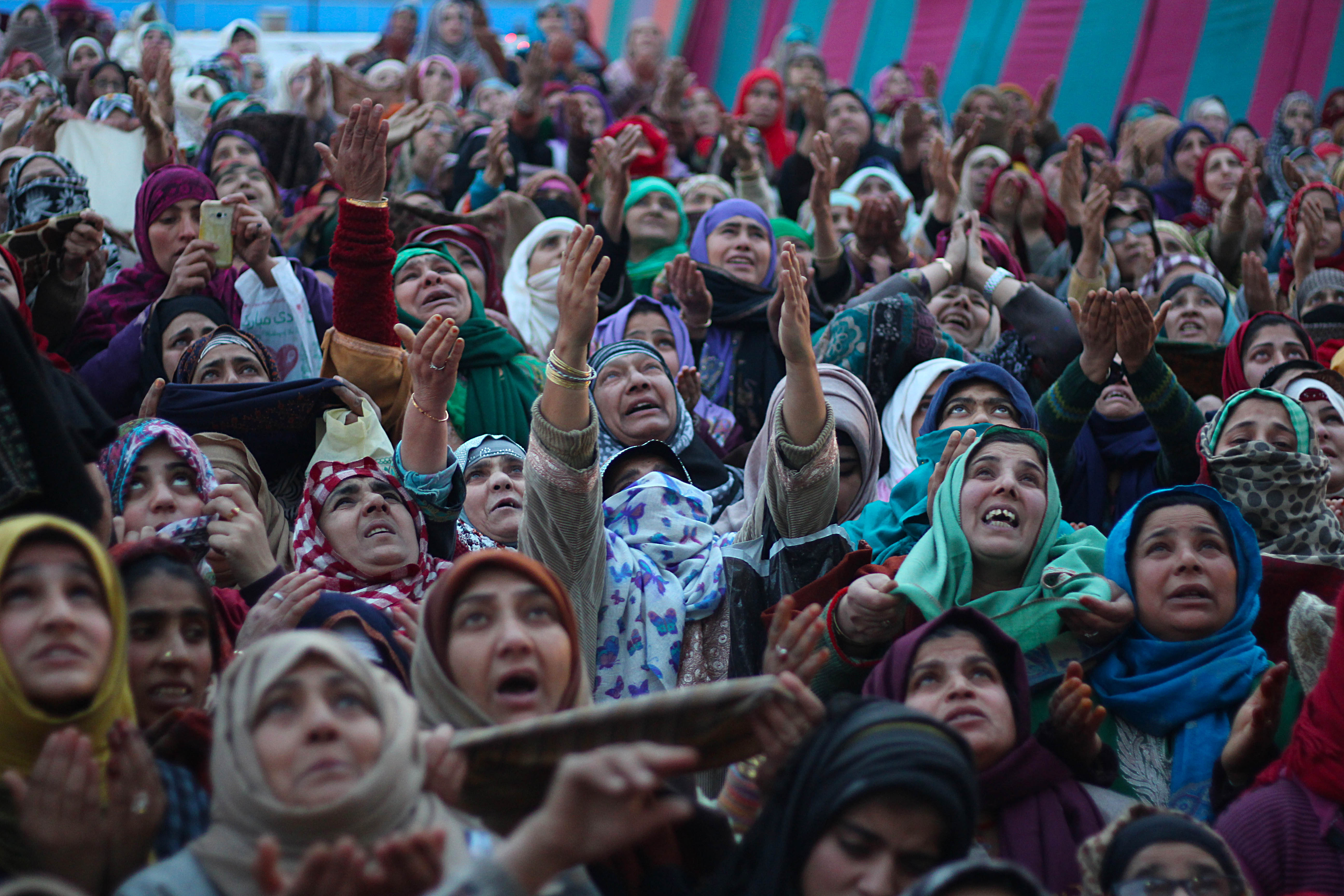 SRINAGAR, INDIA - DECEMBER 12: Kashmiri Muslim women react as a cleric (not in picture ) displays the relic believed to be the hair from the beard of Prophet Muhammed (saw) during a ceremony marking the birthday anniversary of Prophet Mohammad, Mawlid al Nabi, at the Hazartabal shrine in Srinagar, the summer capital of Indian controlled Kashmir, on December 12, 2016.